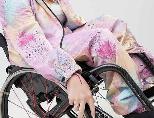Una mujer en silla de ruedas sonríe a la cámara.