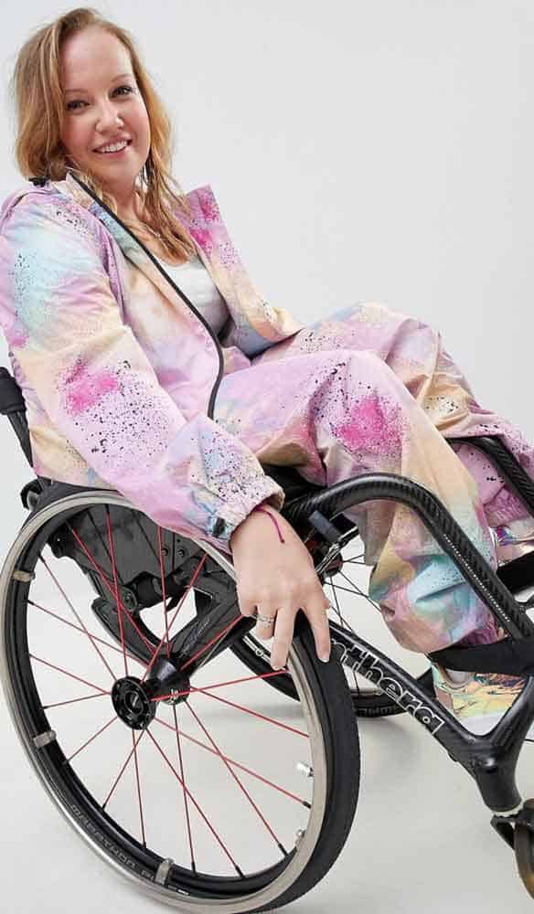 Una mujer en silla de ruedas sonríe a la cámara.