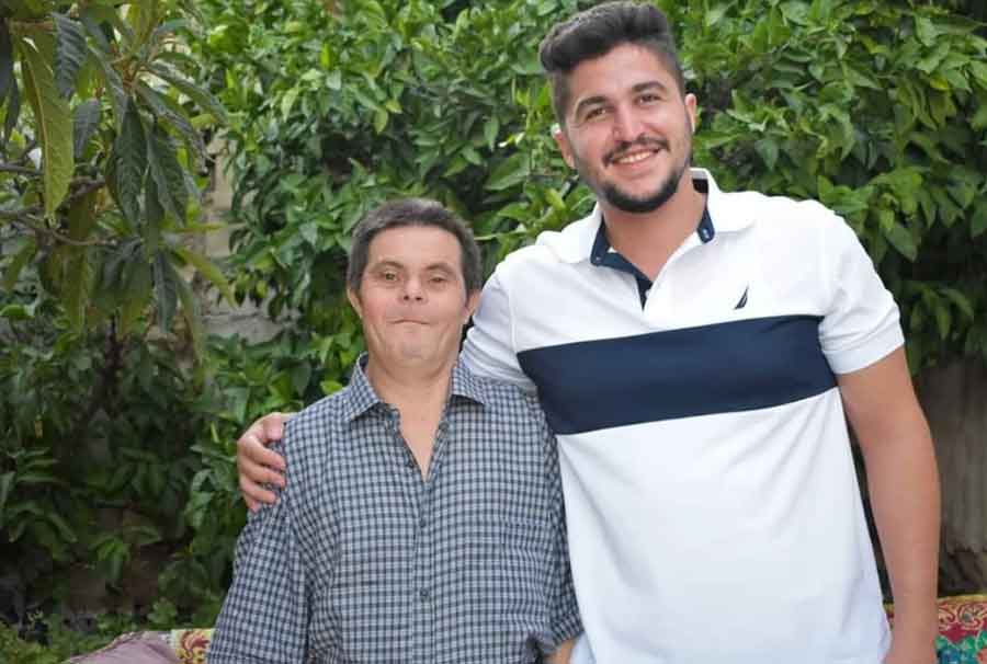 foto donde aparece un joven abrazado a su padre que tiene síndrome de Down. Ambos sonríen y miran a la cámara.