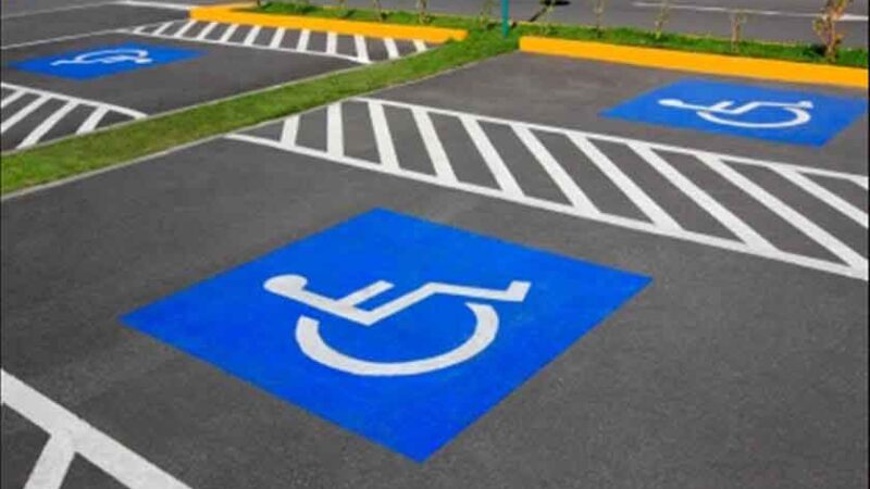 Foto de varios estacionamientos azules con el símbolo de la discapacidad, indicando que están reservados