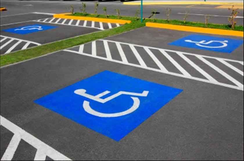 Foto de varios estacionamientos azules con el símbolo de la discapacidad, indicando que están reservados