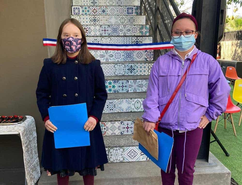 Dos mujeres con Síndrome de Down usando mascarilla