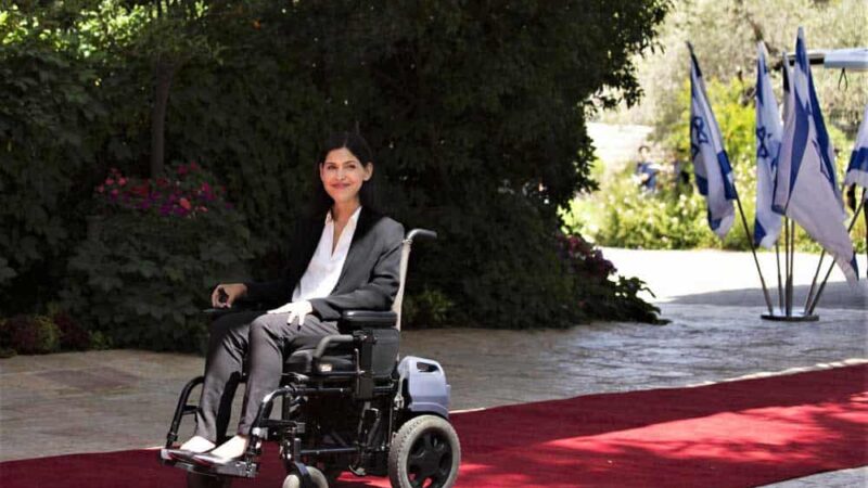 Una mujer en silla de ruedas sobre una alfombra roja