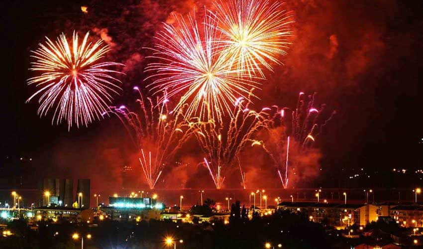 Foto del puerto de valparaíso de noche con muchos fuegos artificiales en el cielo.