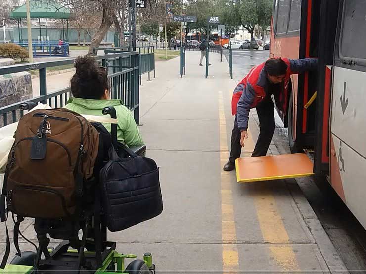 Conductor de transantiago habilitando rampa y persona en silla de ruedas
