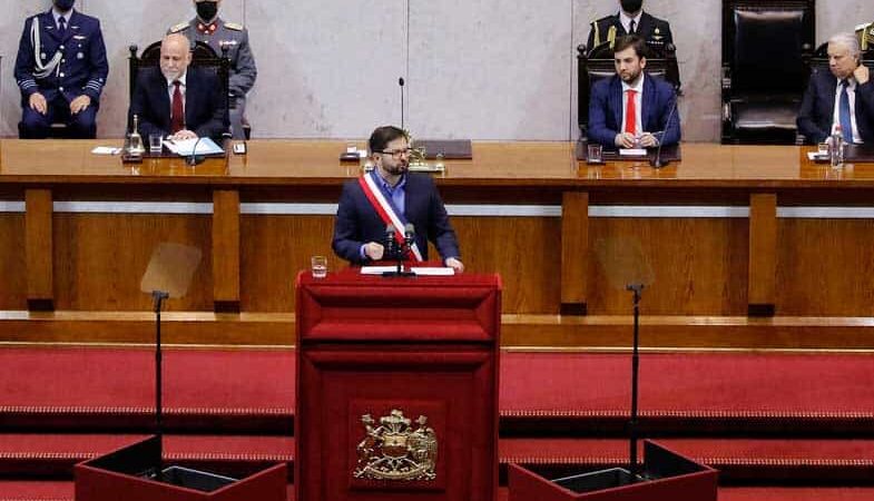 Foto dentro del congreso nacional donde aparece el presidente gabriel boric hablando sobre un estrado vestido de terno y con la banda presidencial.