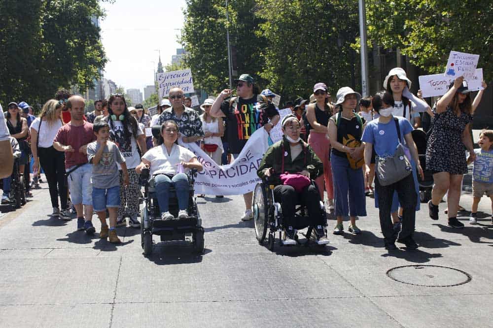 Foto de un grupo de personas con diversos tipos de discapacidad marchando por la alameda en santiago.