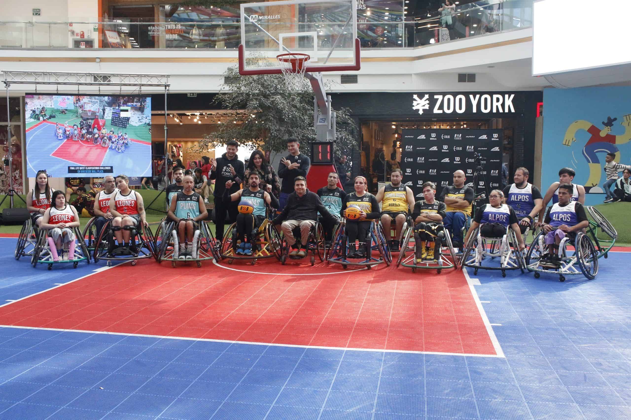Foto sacada al interior de un mall donde se instaló una pequeña cancha de básquetbol, y aparecen cerca de 20 personas en silla de ruedas y con ropa deportiva posando para la foto oficial.