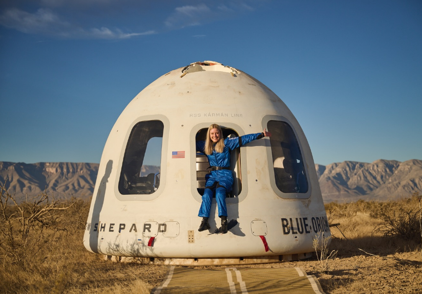 Mujer con movilidad reducida sentada afuera de una cápsula espacial