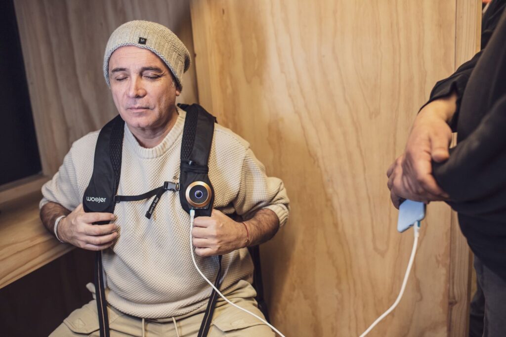 Hombre sentado con ojos cerrados sintiendo música con chaleco vibratorio