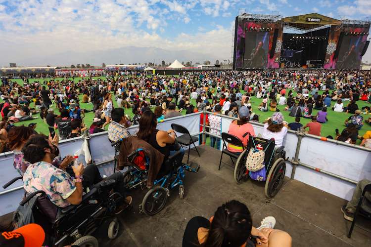 Escenario lollapalooza y personas en silla de ruedas mirando