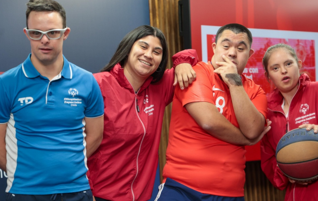 Cuatro atletas con discapacidad intelectual sonriendo a la cámara
