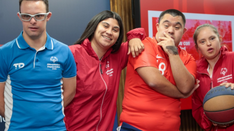 Cuatro atletas con discapacidad intelectual sonriendo a la cámara