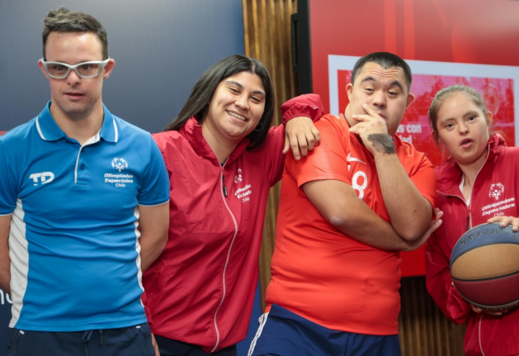 Cuatro atletas con discapacidad intelectual sonriendo a la cámara