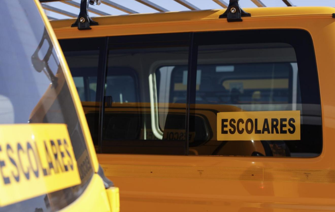Fotografía furgón escolar amarillo junto con el letrero "escolares"