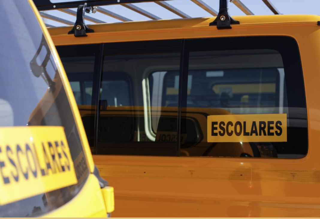 Fotografía furgón escolar amarillo junto con el letrero "escolares"