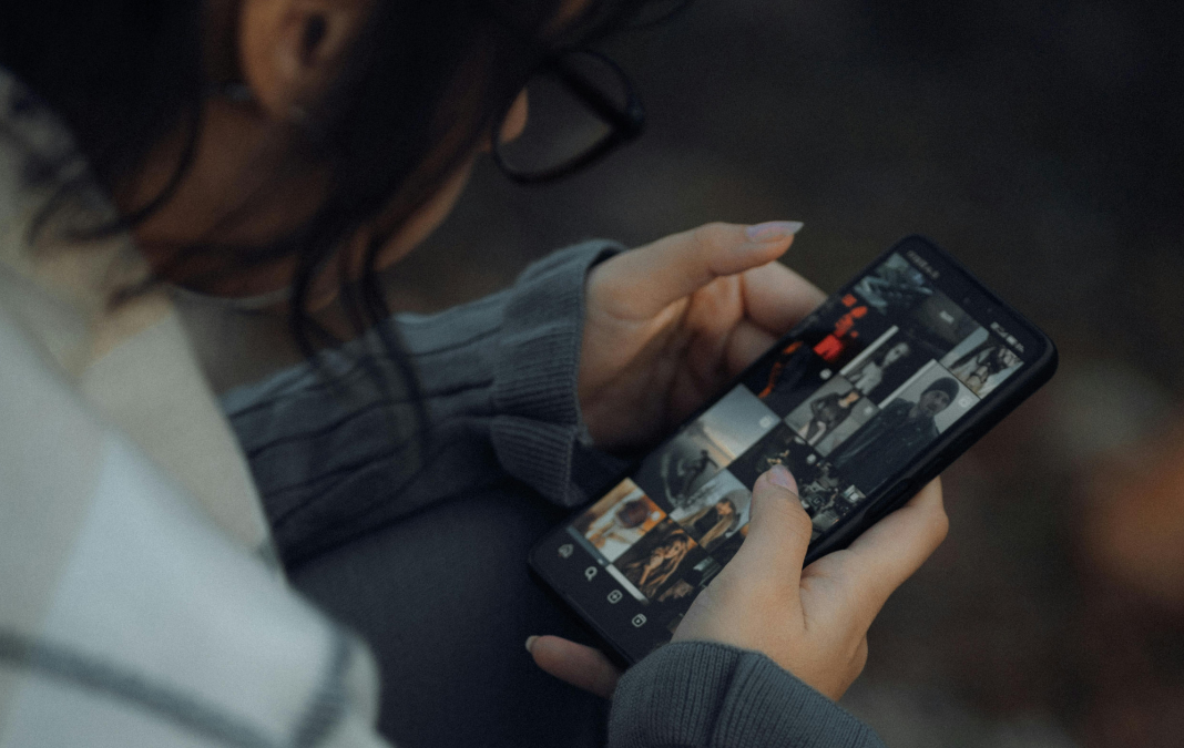 Fotografía de persona de espalda mirando celular