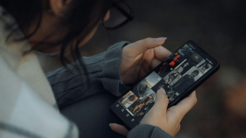 Fotografía de persona de espalda mirando celular
