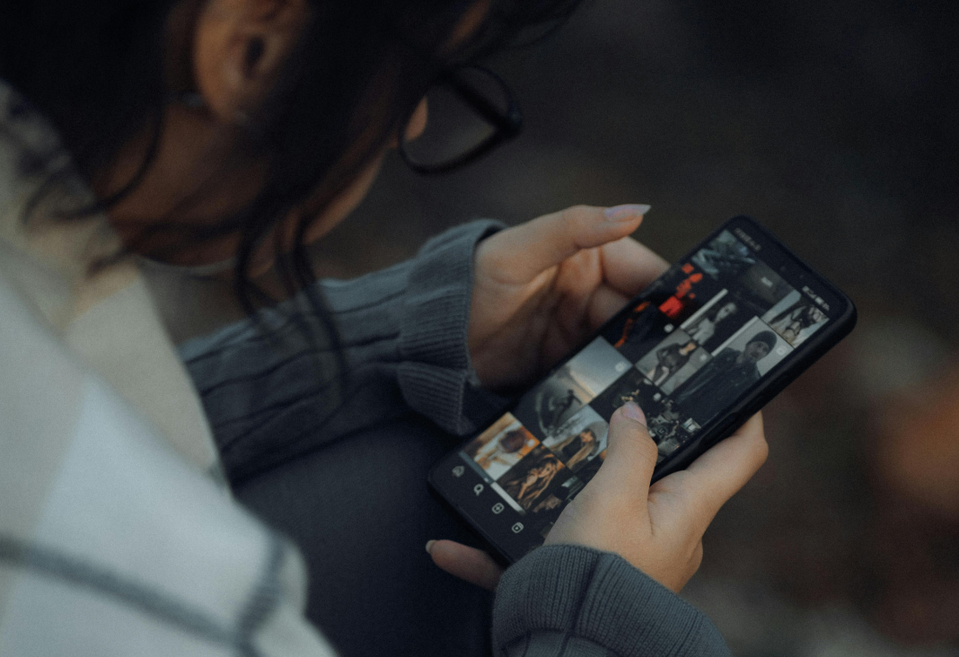 Fotografía de persona de espalda mirando celular
