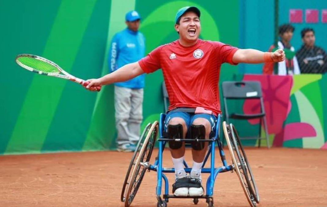 Jugador de tenis en silla de rueda con los brazos extendidos celebrando