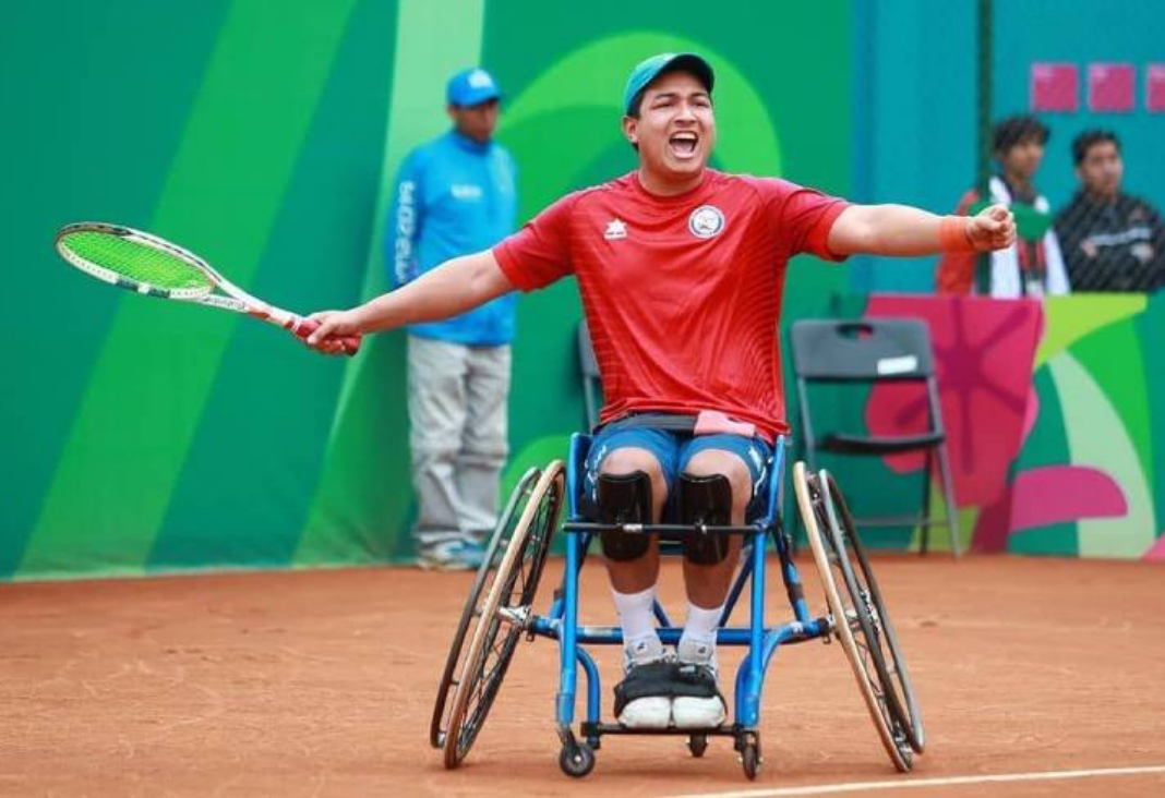 Jugador de tenis en silla de rueda con los brazos extendidos celebrando