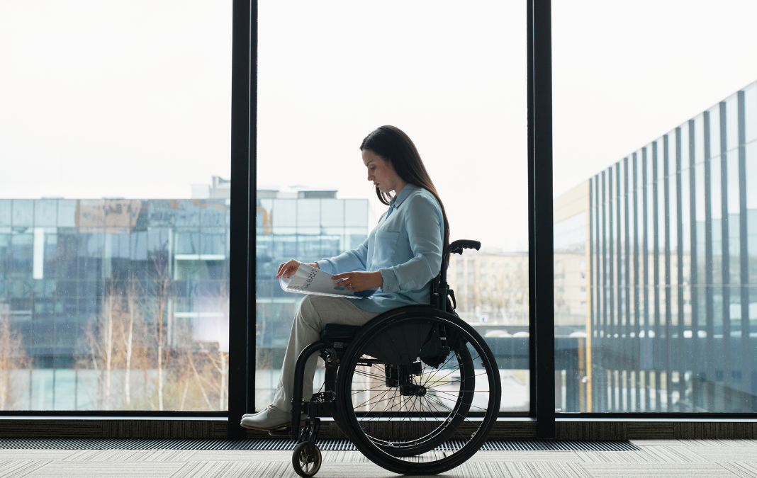Fotografía de mujer en silla de ruedas vestida formal en un pasillo