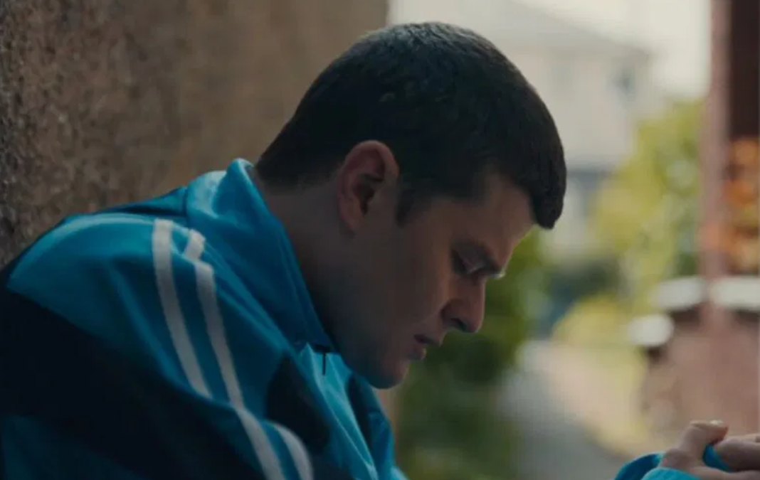 Joven de lado mirando hacia abajo y triste