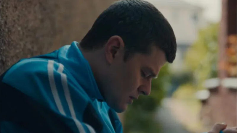 Joven de lado mirando hacia abajo y triste