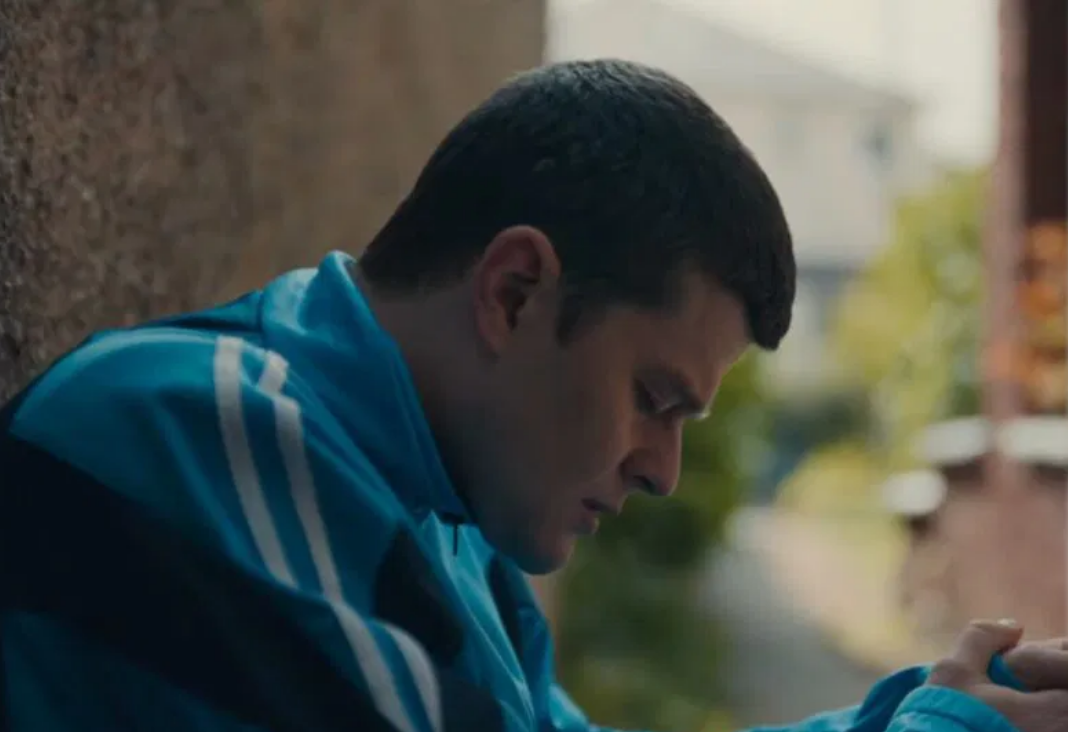 Joven de lado mirando hacia abajo y triste