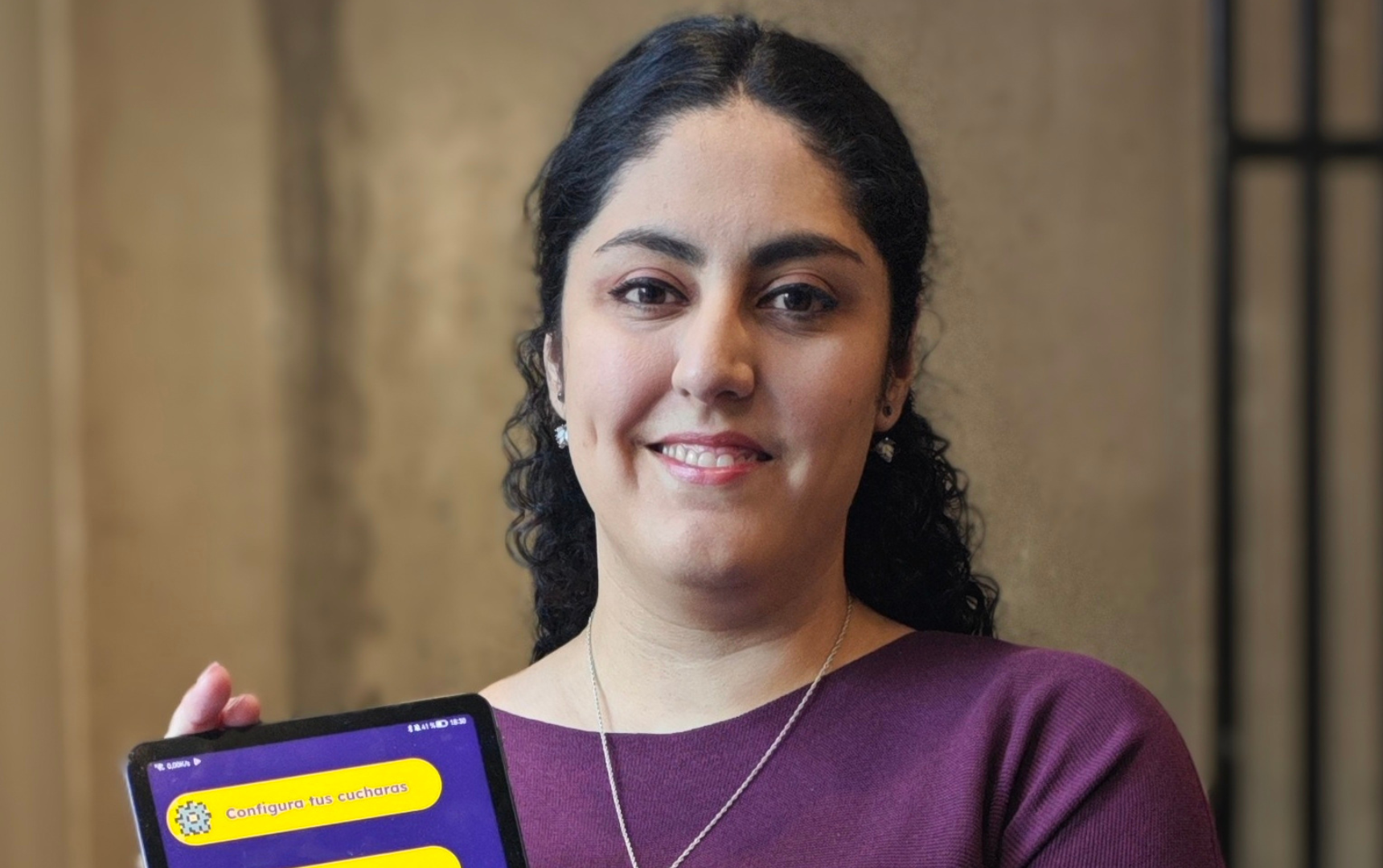 Mujer posando con una tablet mostrando la app cucharómetro
