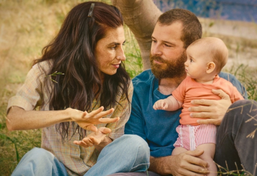 Mujer hablando en lengua de señas a un bebe y su pareja