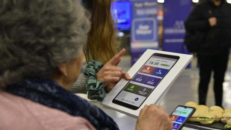 Adulta mayor de espalda mirando un panel para cargar pasaje