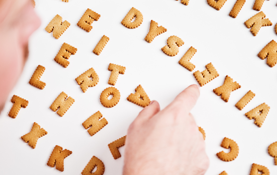 Persona ordenando unas galletas en forma de letras formando la palabra dyslexia