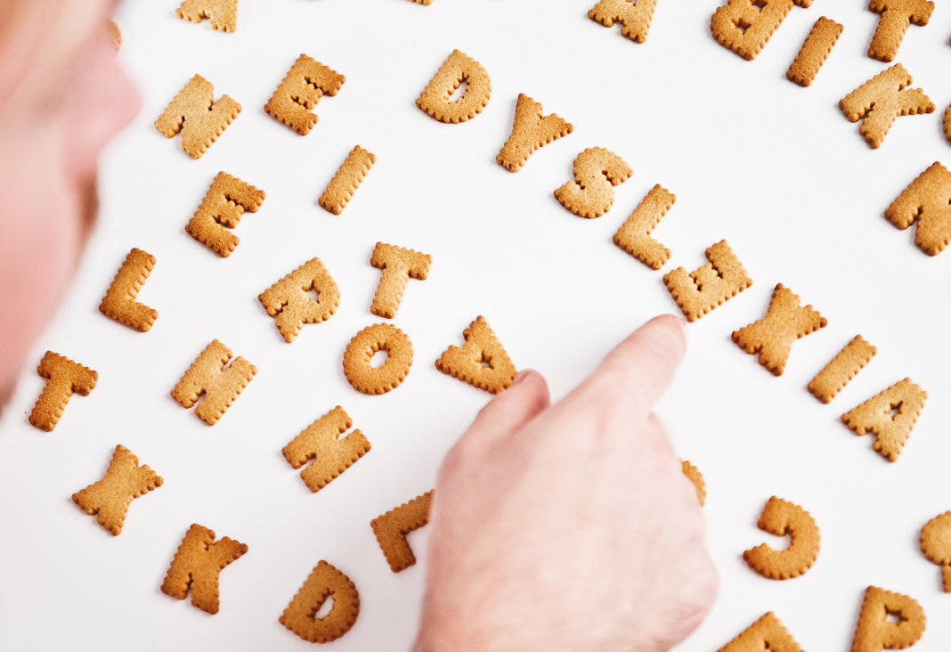 Persona ordenando unas galletas en forma de letras formando la palabra dyslexia