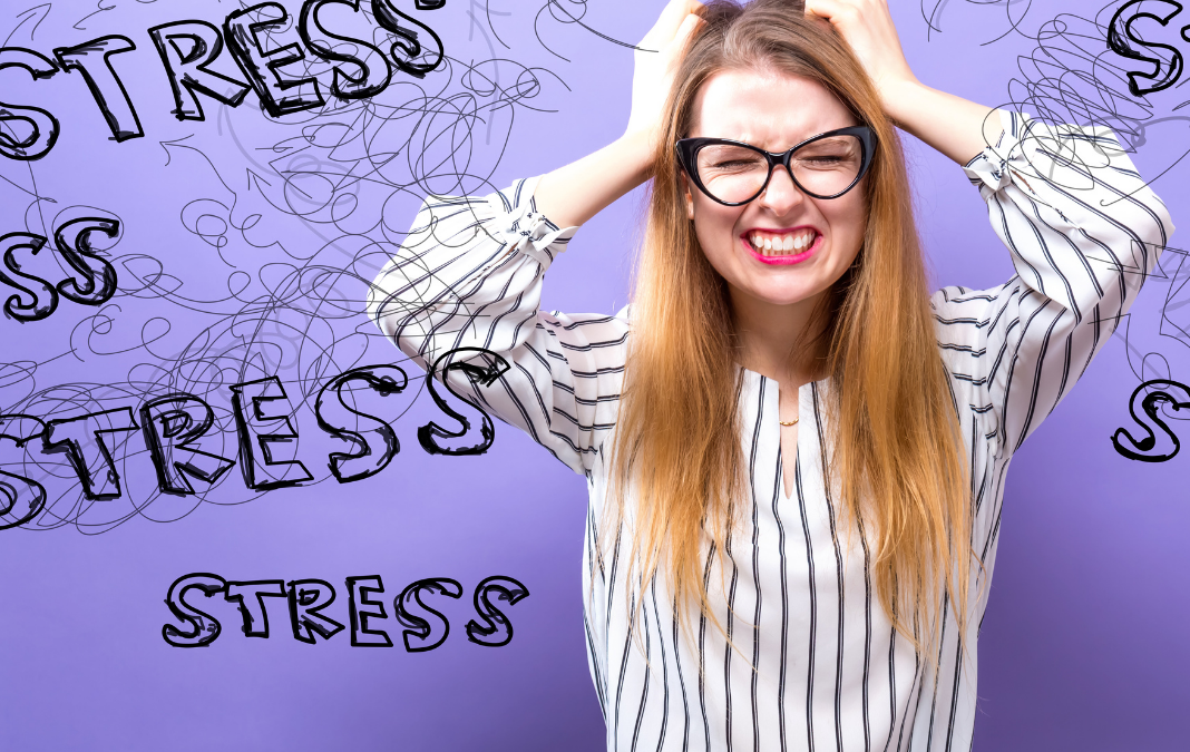 mujer tomándose la cabeza y de fondo la palabra stress
