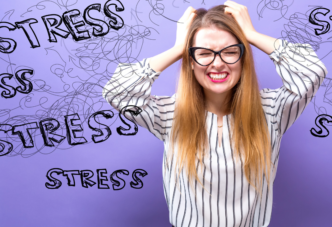 mujer tomándose la cabeza y de fondo la palabra stress