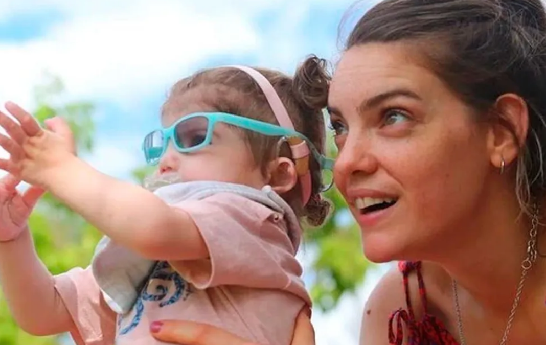 Mujer mirando algo junta a una niña pequeña