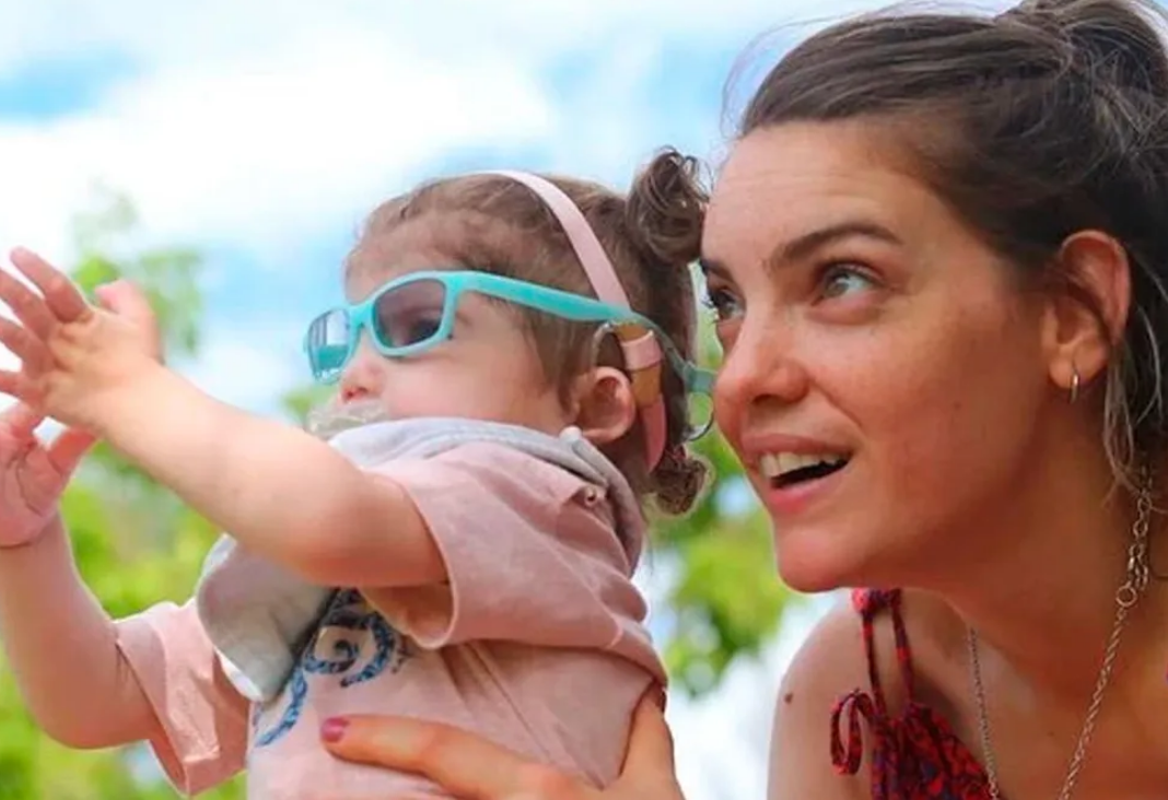 Mujer mirando algo junta a una niña pequeña