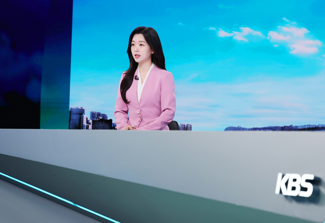 Fotografía de mujer coreana sentada en un set de televisión leyendo noticias