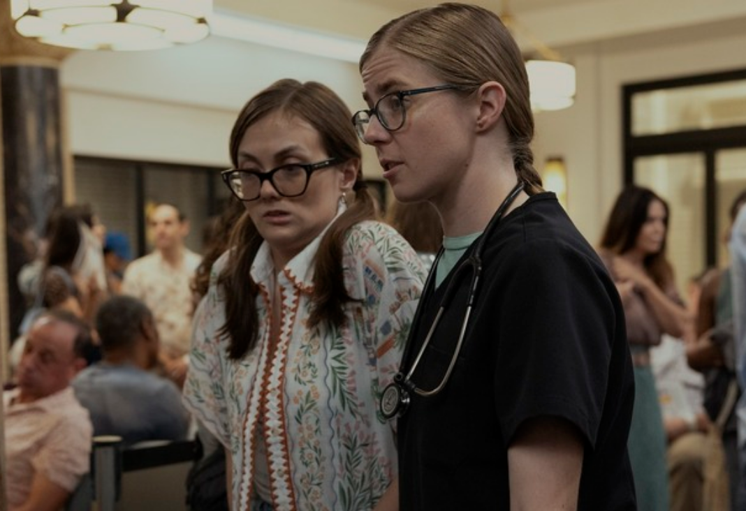 Dos mujeres con anteojos de perfil, una de ellas médico. Pantallazo serie The Pitt