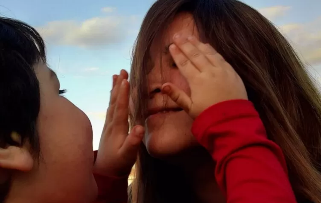 Foto de un niño tapándole los ojos a una mujer