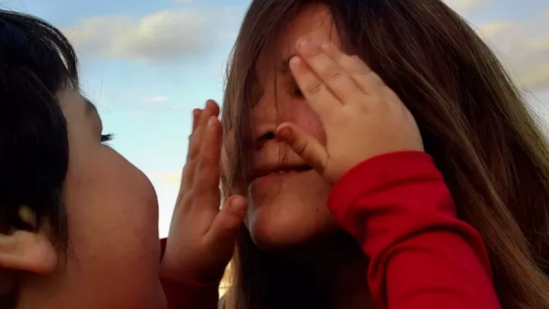 Foto de un niño tapándole los ojos a una mujer