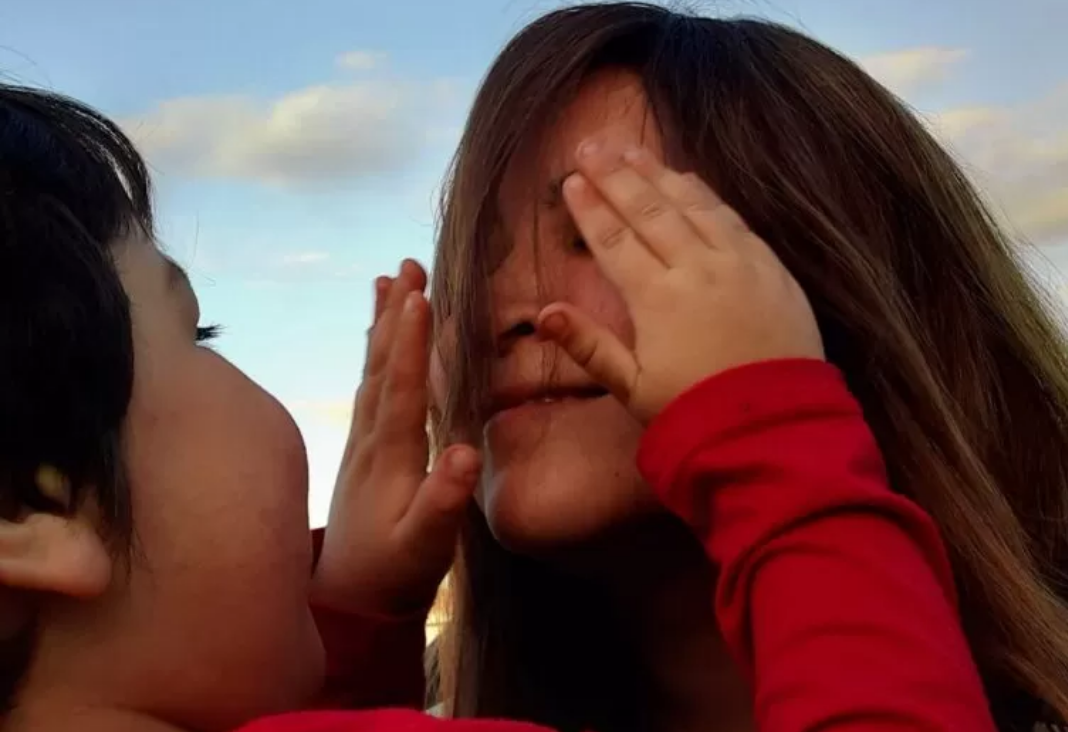 Foto de un niño tapándole los ojos a una mujer