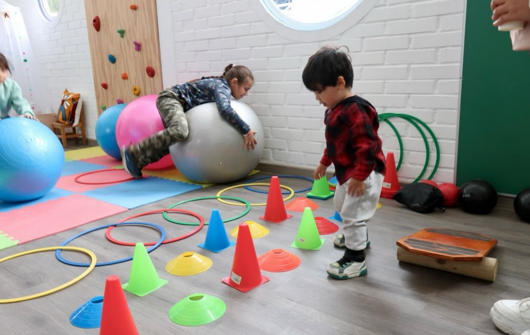 Foto de una niña y un niño jugando en una sala de estimulación