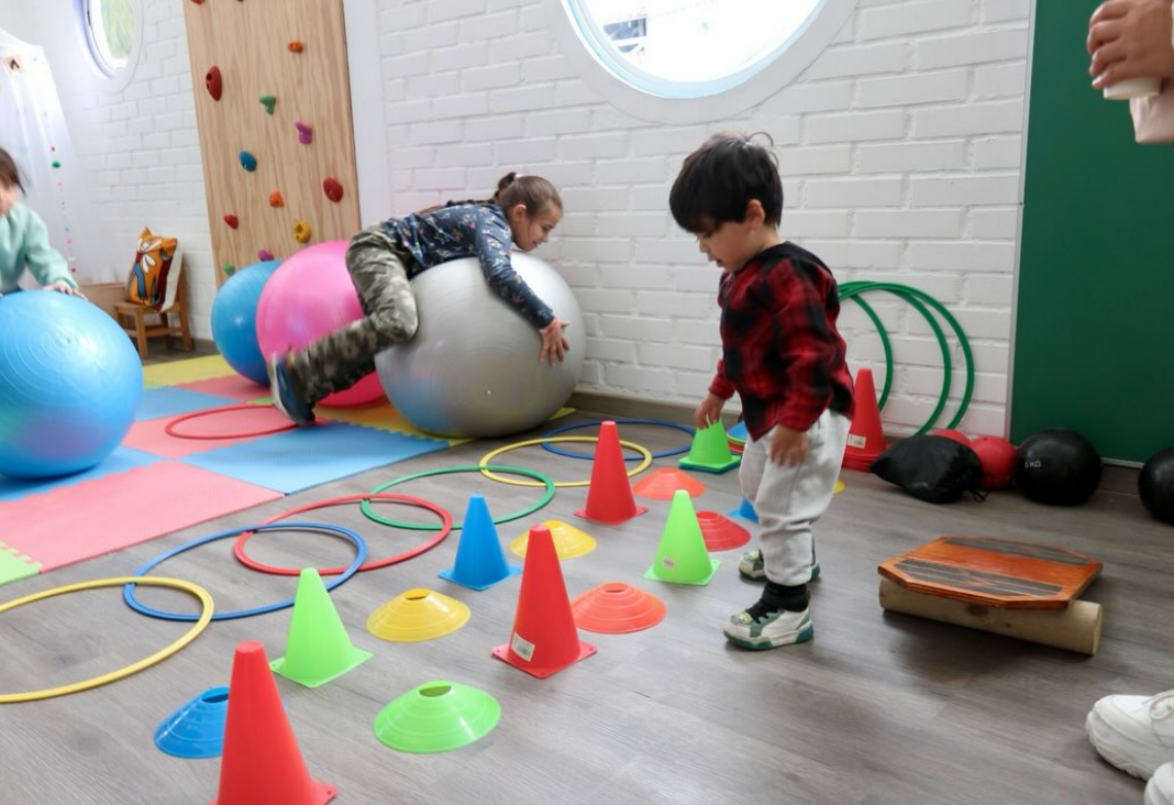 Foto de una niña y un niño jugando en una sala de estimulación