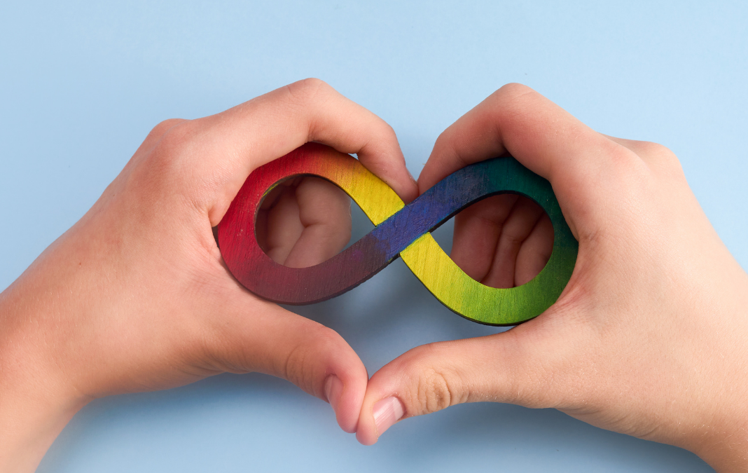 Manos formando un corazón y dentro un infinito en colores
