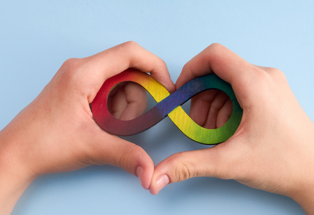 Manos formando un corazón y dentro un infinito en colores