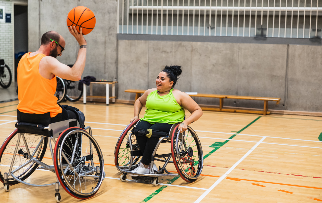 Dos personas en silla de ruedas jugando básquetbol