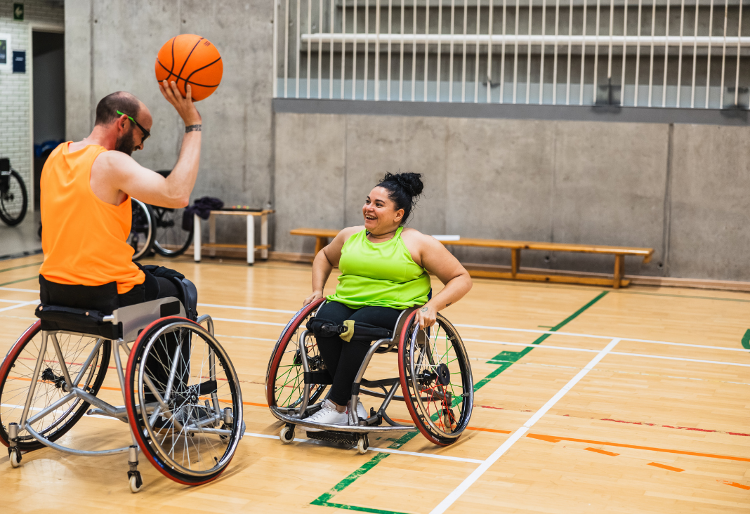 Dos personas en silla de ruedas jugando básquetbol
