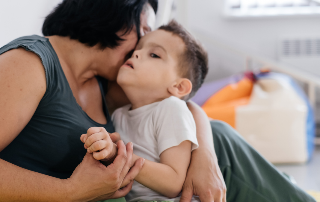 mujer con niño con discapacidad en brazos